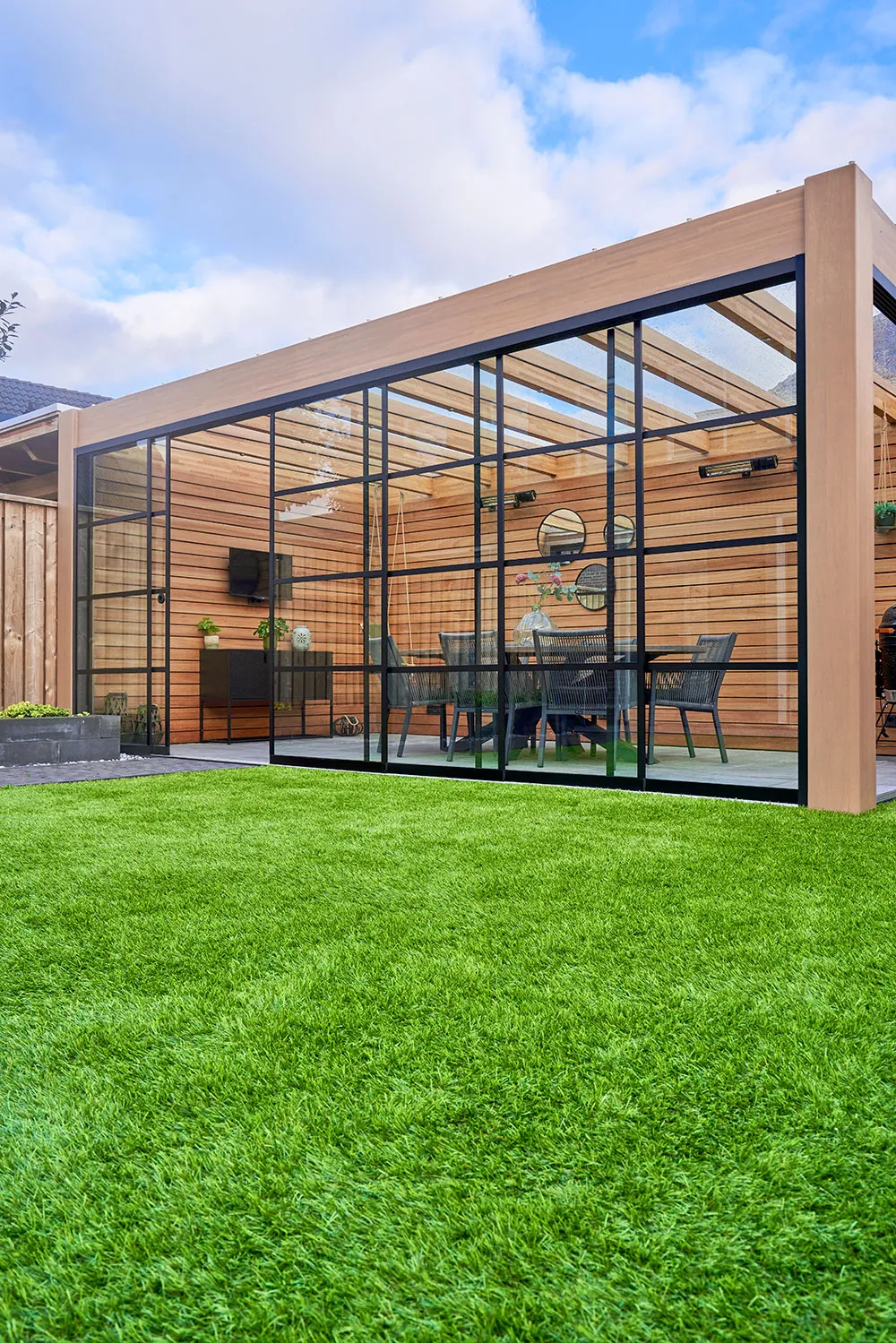 A glass enclosed patio with a table and chairs.