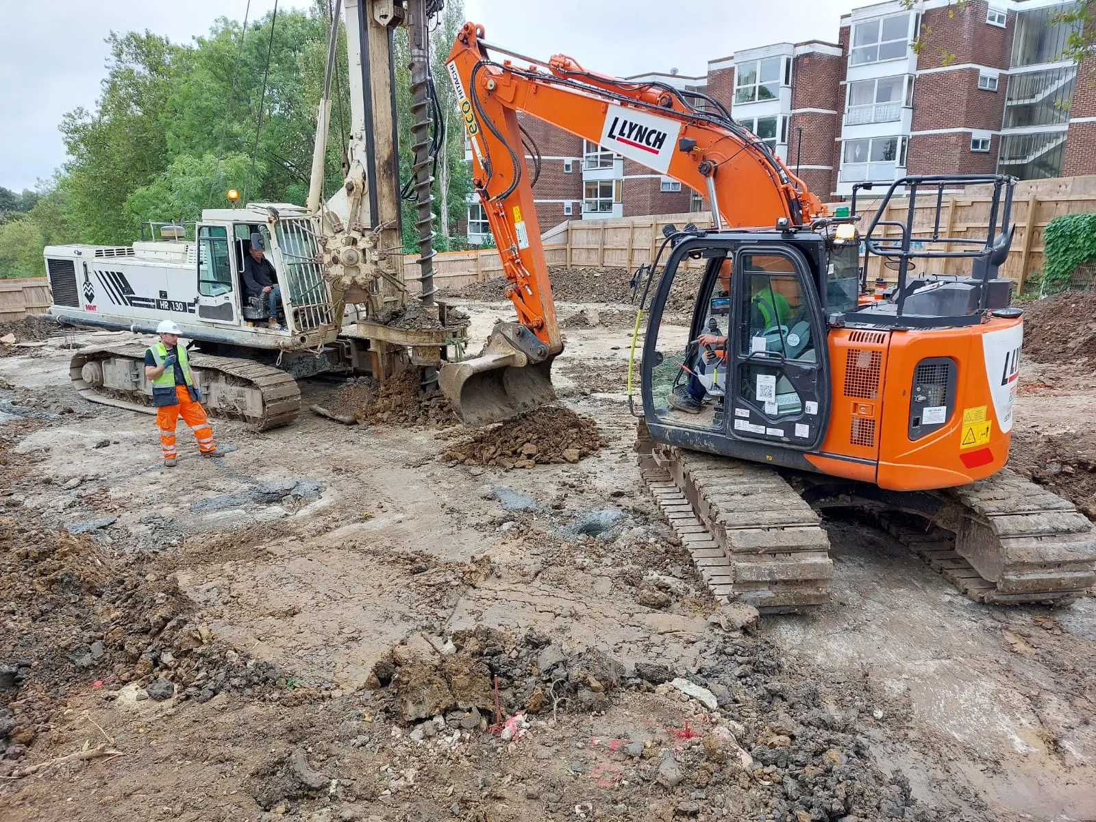 A couple of men standing in front of a bulldozer.